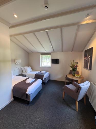 a hotel room with two beds and a chair at Aparthotel Landgoed Culitsrode in Hooge Mierde