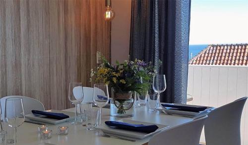 a white table with chairs and a vase of flowers at 5505-Gudhjem-Kirkevej-10-Lejl-20 in Gudhjem