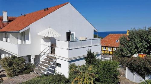a white building with an umbrella on top of it at 5505-Gudhjem-Kirkevej-10-Lejl-20 in Gudhjem