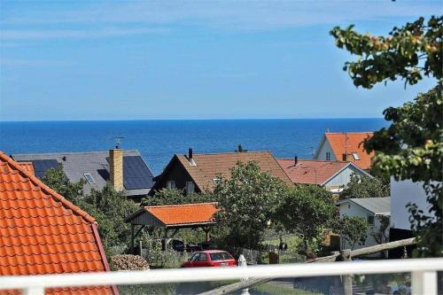 a view of a town with houses and the ocean at 5505-Gudhjem-Kirkevej-10-Lejl-20 in Gudhjem