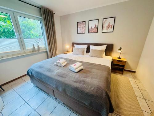 a bedroom with a large bed with two towels on it at Stylisches modernes Apartment, Sauna und Wellness Top Lage in Lübbecke