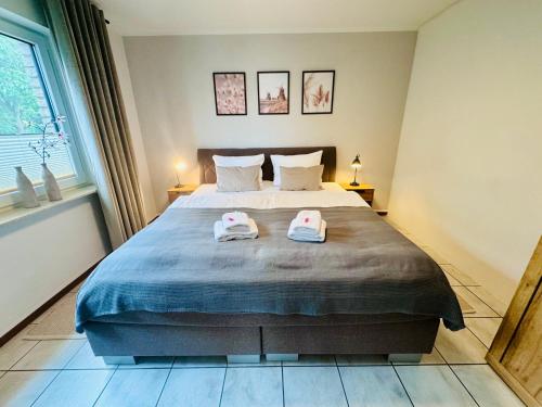 a bedroom with a bed with two towels on it at Stylisches modernes Apartment, Sauna und Wellness Top Lage in Lübbecke