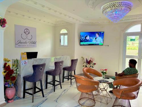 a woman sitting at a bar in a salon at Jacobs Hôtel in Douala