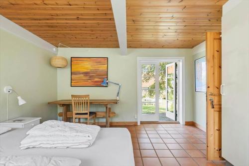 a bedroom with a bed and a desk and a table at 5617-Svaneke-Per-Sorens-Gade-2 in Svaneke