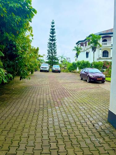 three cars parked in a parking lot next to a building at Jacobs Hôtel in Douala