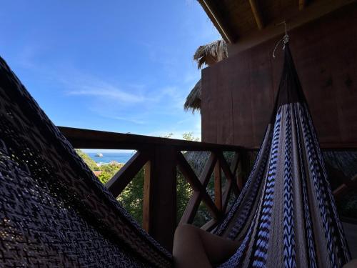 a hammock in a resort with a view of the ocean at Charming Ocean View Apartment, Casa Xochi in San Agustinillo