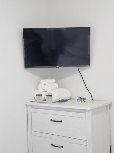 a flat screen tv on top of a white dresser at CEDAR Double Room with attached private Bathroom and Balcony in Toronto, ON, Canada in Toronto