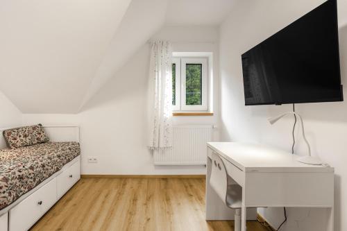 a bedroom with a bed and a desk with a television at Chata u Tichého Lesa Pernink in Pernink