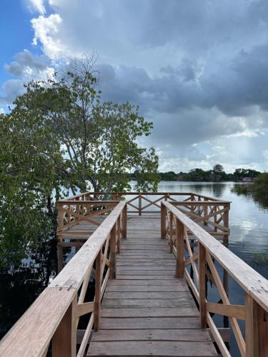 a wooden bridge over a body of water at Amazon Private Tours Jungle Lodge in Manacapuru