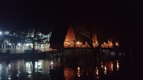 a night view of a building with lights in the water at Amazon Private Tours Jungle Lodge in Manacapuru