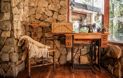 a stone wall with a desk and a sink in a room at Equs Posada de Campo in San Carlos de Bariloche