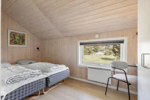 Vester Sømarkenにある1405-Aakirkeby-Holsteroddevej-22のベッドと窓のある小さな寝室
