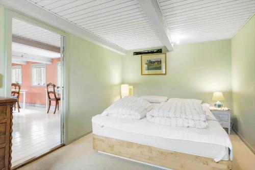 ein Schlafzimmer mit einem großen weißen Bett in einem Zimmer in der Unterkunft 5568 Gudhjem - Melsted By 19 in Gudhjem