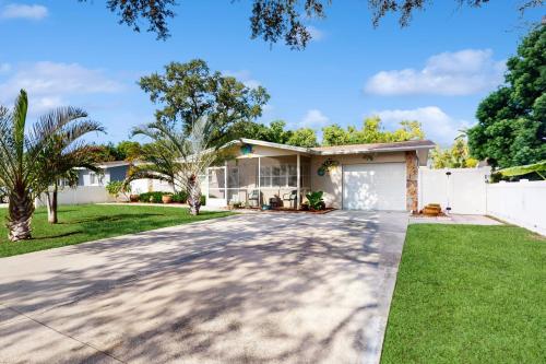 a house with a driveway in front of it at Avocado Cottage in Seminole