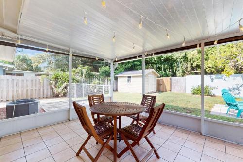 a patio with a table and chairs on a porch at Avocado Cottage in Seminole