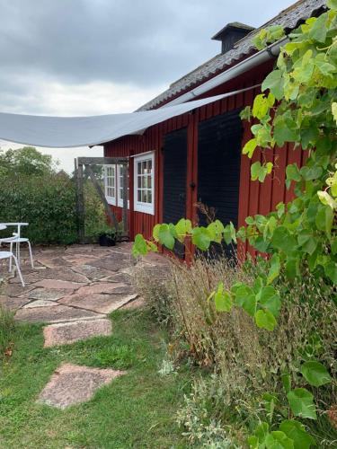 a red house with a picnic table in front of it at Stuga på gård i Böda socken in Löttorp