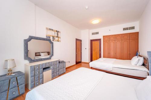 a bedroom with two beds and a mirror at Luxury Oceanfront Fully Furnished 2BR! in Ajman 