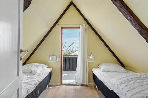 due letti in una stanza con una grande finestra di 5554-Svaneke-Bakken-1 a Svaneke