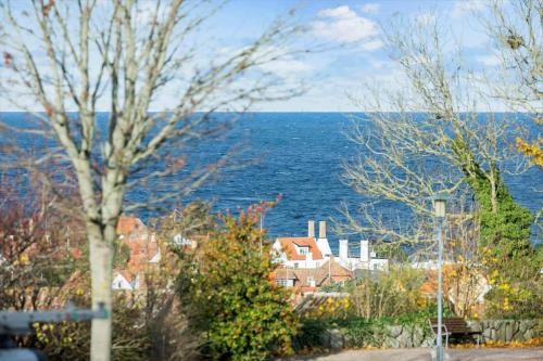a view of the ocean and a house with trees at 5647-Gudhjem-Kirkevej-10-lejl-3 in Gudhjem