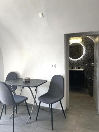a table and four chairs in a room at Aethera Apartments in Megalokhori