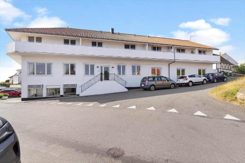 a large white building with cars parked in front of it at 5640-Gudhjem-Kirkevej-10-lejl-1 in Gudhjem