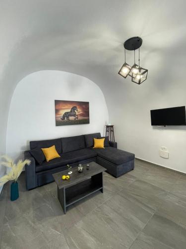 a living room with a blue couch and a table at Aethera Apartments in Megalokhori