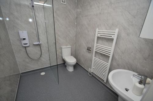 a bathroom with a shower and a toilet and a sink at Spacious 4-Bedroom Family Home in Giffnock Glasgow in Pollokshaws