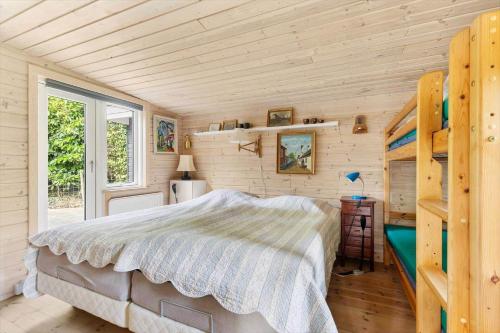 a bedroom with a bed in a room with wooden walls at 6832-Hasle-Toftegardsvej-20-C in Hasle