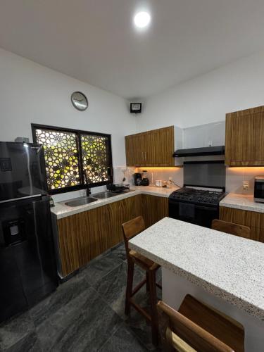 a kitchen with a black refrigerator and a table at Houzze Plety in Brisas de Zicatela