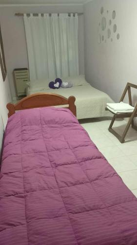 a bedroom with a bed with a purple blanket at La casa de Angelita in Trelew