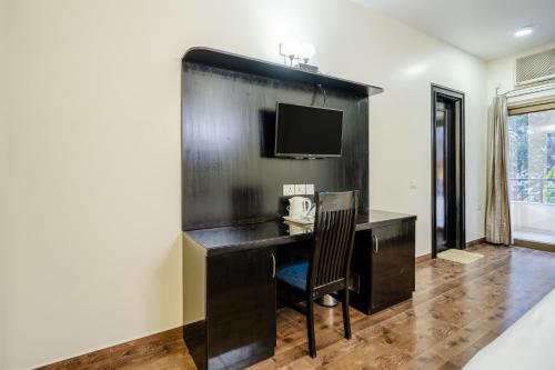 a hotel room with a desk with a telephone at Galleria Inn -Galleria Market & Golf Course in Gurgaon