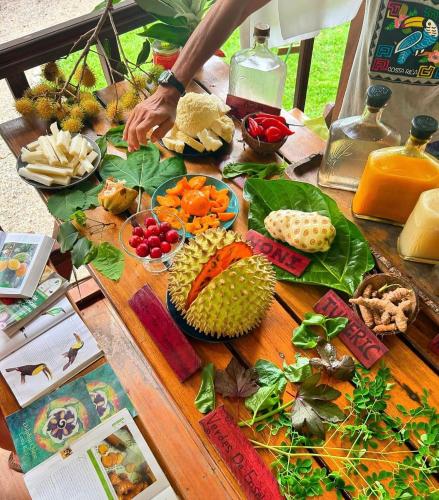 a table with a bunch of fruits and vegetables on it at Dolphin Quest Jungle Lodge in Piedras Blancas