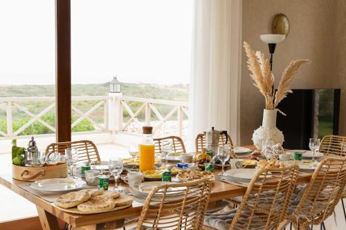 una mesa de madera con comida y sillas en Villa Cactuswell, en Essaouira