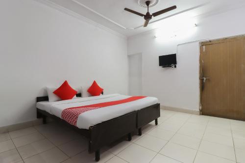 a bedroom with a bed with red pillows on it at Hotel O Shri Tirupati in Nilmatha