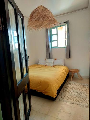 a bedroom with a bed in a room with a window at Moroccan Boho Surf House in Agadir