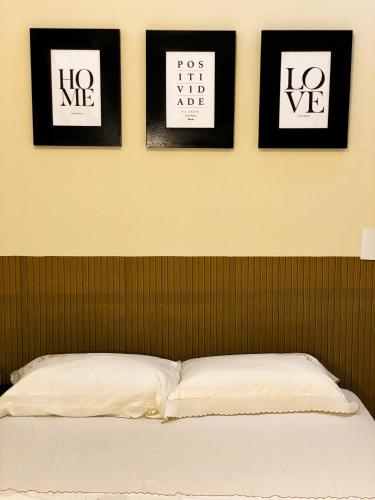 a bedroom with four framed pictures on the wall at Casa No Centro de Caldas Novas in Caldas Novas