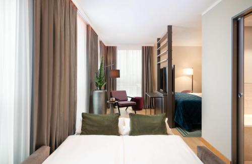a hotel room with a bed and a bedroom at Leonardo Royal Hotel Nürnberg in Nuremberg
