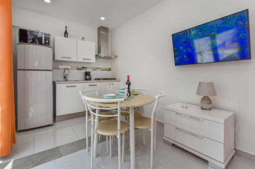 a kitchen with a table and chairs and a refrigerator at Hotel experience with daily housekeeping and laundry in Oranjestad