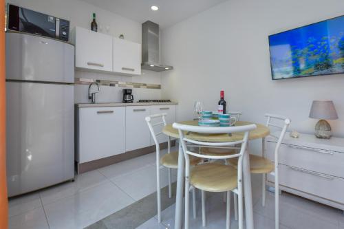 a kitchen with a table and chairs and a refrigerator at Hotel experience with daily housekeeping and laundry in Oranjestad