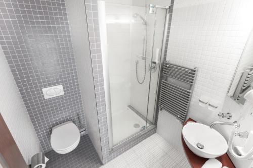 a bathroom with two toilets and a shower at Hotel Conti in Olomouc