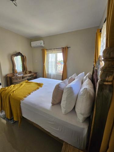 a bedroom with a large bed with white pillows at Tranquility Loft in Ocho Rios