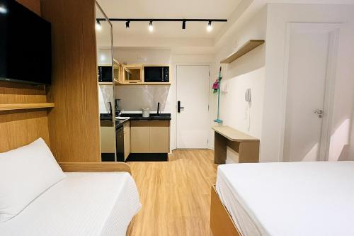 a small room with a bed and a kitchen at IBZ1308 - Studio C Sacada Pscina Jacuzzi Academia in Curitiba