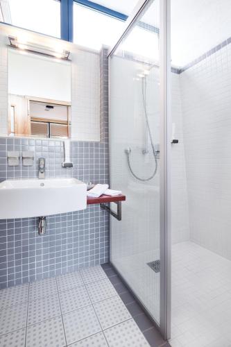 a bathroom with a sink and a shower at Hotel Conti in Olomouc