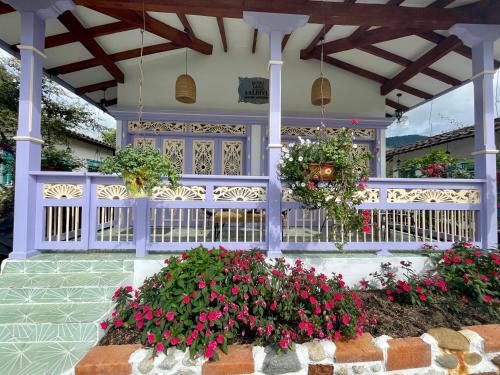 a porch with flowers and a white fence at Hotel Lago Valdivia in Jardin