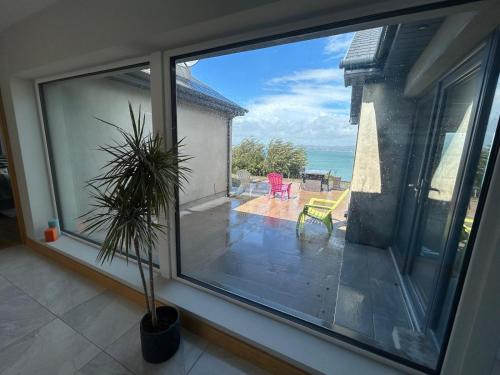 a window of a house with a view of the ocean at Cois Cuan in Ballynagaul