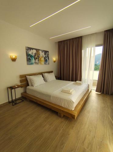 a bedroom with a large bed and a large window at Marios Rooms in Himare