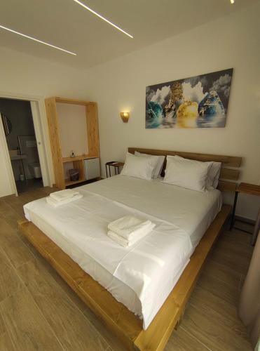 a large white bed with two towels on it at Marios Rooms in Himare