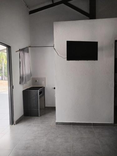 a room with a white wall with a television on it at JYM apartaestudios Doradal in Doradal