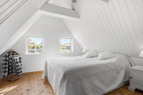a white bedroom with a bed and two windows at LF14031-Roslev-Stranddalen-131 in Roslev
