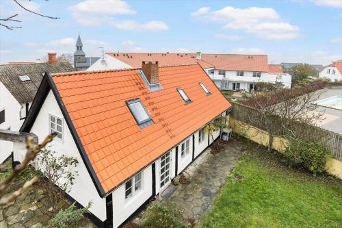 an orange roof on a white house at 5561-Gudhjem-Kirkevej-8 in Gudhjem
